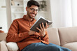 © Prostock-studio - Smiling Arab man in glasses reading book