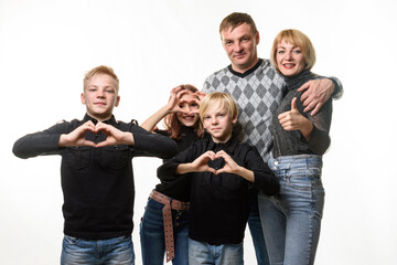 Wall Mural - Portrait of an ordinary large family, teenagers show a gesture in the shape of a heart and joyfully look into the frame