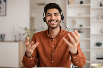 Wall Mural - Arab man having video call and talking at webcam