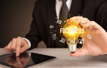 Businessman holding a light bulb, social media concept