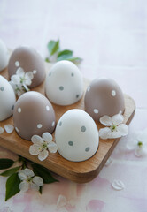  Easter eggs in wooden tray on pink tile background