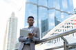 © Wongsakorn - Business people in city. Portrait of an handsome businessman. Modern businessman. Confident young man in full suit and glasses while standing outdoors looking away with cityscape in the background