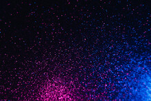 Color Glitter Overlay. Blur Sparkles. Bokeh Light. Night Sky Stars Reflection. Neon Blue Magenta Pink Grain Texture Glow On Dark Black Shimmering Abstract Background.
