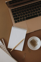 Wall Mural - Aesthetic minimalist home office workspace desk. Laptop computer, notebook on brown background. Flat lay, top view work, business concept