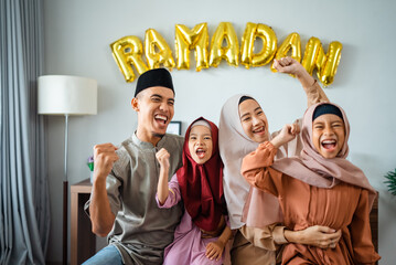 excited muslim family portrait together raise arm