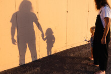 Shadow Of Man And Boy On Yellow Wall