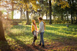 © Westend61 - Smiling couple holding hands standing together at autumn park