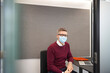© Westend61 - Businessman wearing protective face mask sitting on chair at office