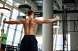 © Georgii - Rear view of Attractive young fit and toned sportswoman working out with battle ropes. Motion blur