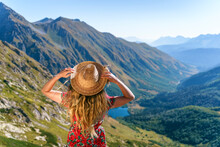 Woman Wearing Straw Hat Looking At Caucasus Mountains On Sunny Day, Sochi, Russia