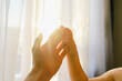 © Westend61 - Boy touching mother's hand in front of curtain at home