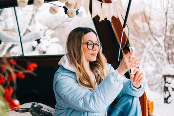 Wall Mural - Young caucasian woman taking photo, sitting in a car while traveling in road trip.