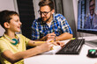 © Mediteraneo - Schoolboy educate online. Father helps his son with home work. Boy in video conference with teacher on computer at home.