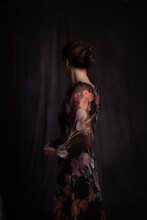 Classic Dark Painterly Portrait Of A Woman In Floral Dress Seen From Behind In Old Masters Style