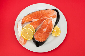 Wall Mural - raw fresh salmon on ceramic plate on red