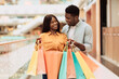 © Prostock-studio - Happy black couple holding shopping bags looking at each other