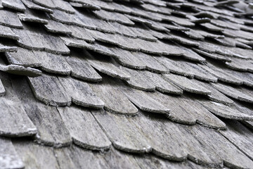 Poster - Thin layer of white snow laying on wooden weathered roof tiles.