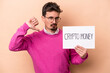 © Asier - Young caucasian man holding a crypto money placard isolated on beige background feels proud and self confident, example to follow.