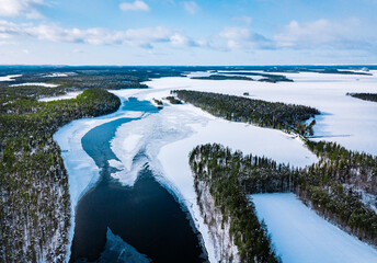 Canvas Print - Aerial view of snow winter river with green forest