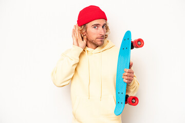 Wall Mural - Young skater caucasian man isolated on white background trying to listening a gossip.