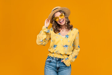 stylish happy smiling blond woman on vacation in straw on yellow background