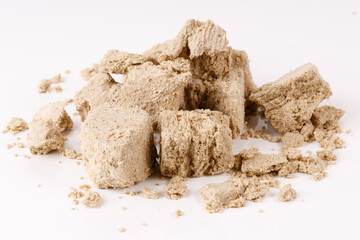 Poster - a large pile of halva with crumbs on a white background