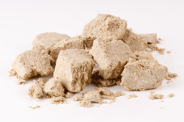 Poster - a large pile of halva with crumbs on a white background