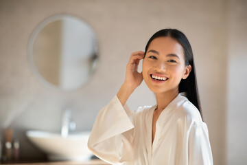 Wall Mural - Positive attractive japanese lady posing at modern bathroom