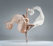 Beautiful Ballerina Dancing In The Body Color Ballet Leotard With Body Color Cloth. She Danced On Ballet Pointe Shoes.