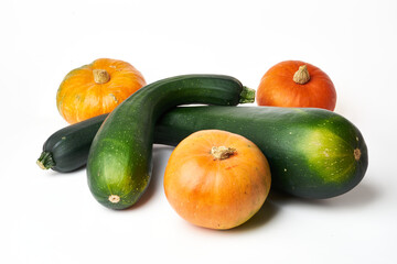 two green squash and three orange pumpkins on a white background