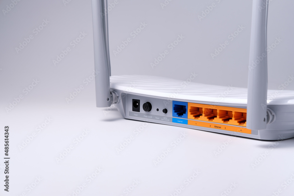 Wi-Fi router with RJ-45 connectors is isolated on a white-gray ...