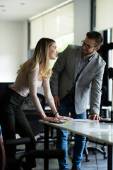 Wall Mural - Colleagues in office. Businesswoman and businessman discussing work in office.