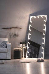 Canvas Print - Stylish mirror with light bulbs and comfortable sofa in living room. Interior design