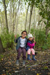 © Trevor Adeline/Caia Image - Portrait cute brother and sister on swing in woods
