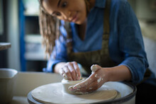Young Woman At Pottery Wheel In Art Studio
