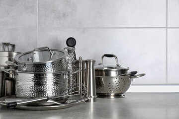 Set of different cooking utensils on grey countertop in kitchen