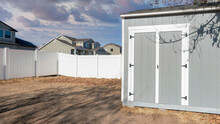 Panorama Puffy Clouds At Sunset Gray Metal With Double Door Shed Exterior On The Backyard Of A H