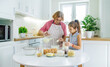 © yanadjan - Child and grandmother in the kitchen bakes prepares the dough in the kitchen. Selective focus.