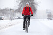 Riding on bicycle in snowy and slippery pathway at winter season, man with bike moving in city, front view