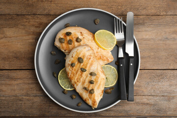 Wall Mural - Delicious chicken fillets with capers and lemon served on wooden table, top view