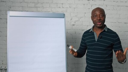black teacher conducts lecture with flipchart