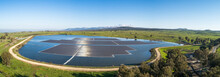 Panoramic Aerial View Of A Water Reservoir Covered With Floating Solar Panels, Orvim Eliyon Reservoir, Golan Heights, Israel.