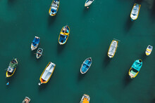 Aerial View Of Tiny Boats Floating In Mediterranean Sea, Marsaxlokk, Malta.