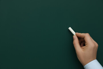 Wall Mural - Man with white chalk near green board, closeup. Space for text