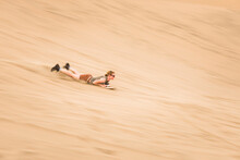 Sand Boarding On Dunes In The Desert At Huacachina, Ica Region, Peru, South America