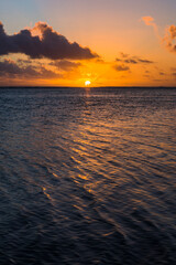 Wall Mural - Tropical sunset background with copy space showing dramatic clouds in the sky over a horizon of the Pacific Ocean, Rarotonga, Cook Islands