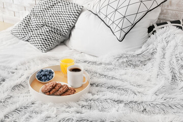 Wall Mural - Tray with tasty breakfast on fluffy plaid