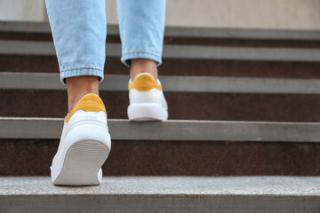 woman walking upstairs outdoors, closeup