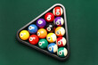 Rack with billiard balls on green table