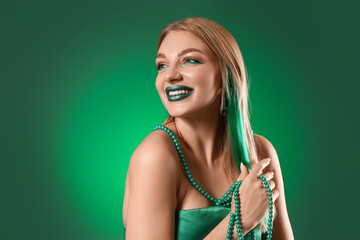 Beautiful young woman on green background. St. Patrick's Day celebration